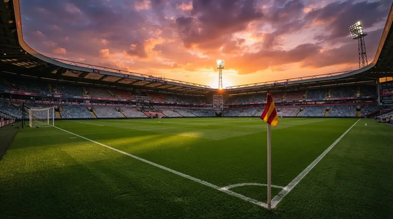 Un estadio de fútbol vacío con torres de iluminación al atardecer